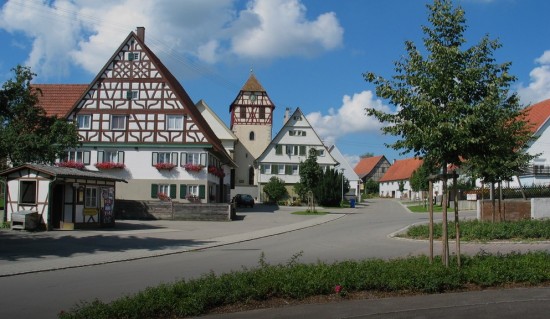 Zusehen ist eine Ortsansicht von Täbingen auf der die Kirche und zwei Häuser zusehen sind